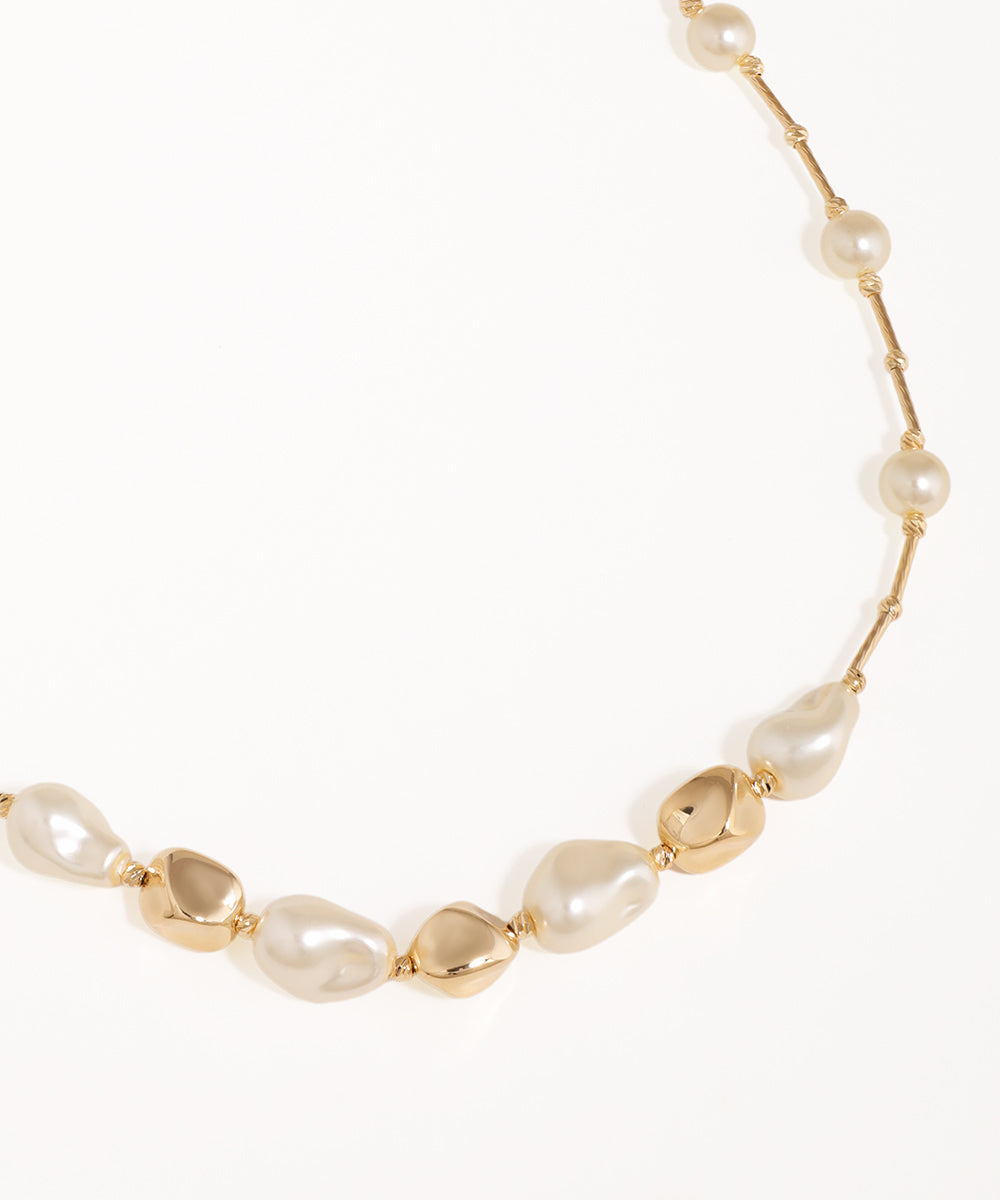 Necklace with gold and pearl beads on a white background
