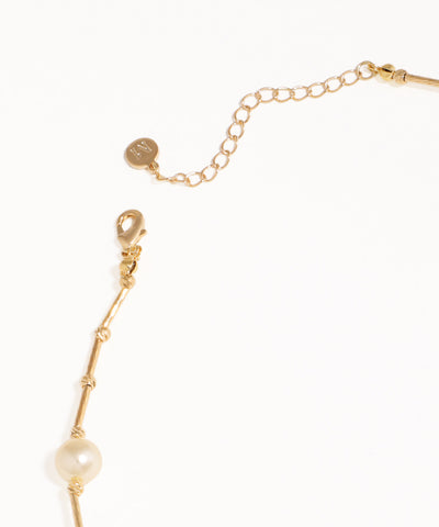 Gold bracelet with a pearl on a white background