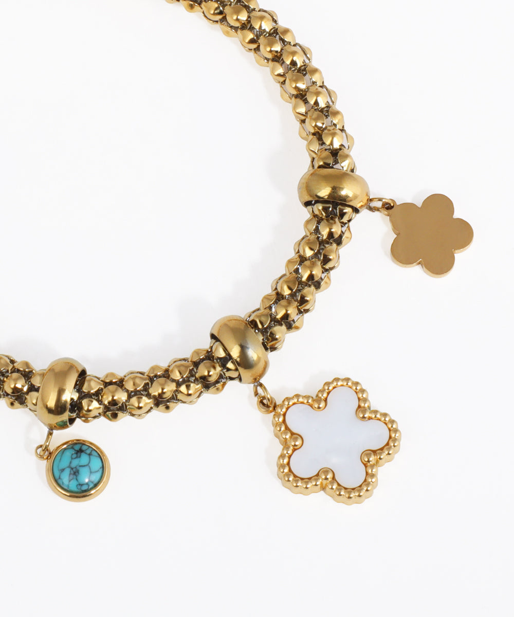 Gold bracelet with charms on a white background