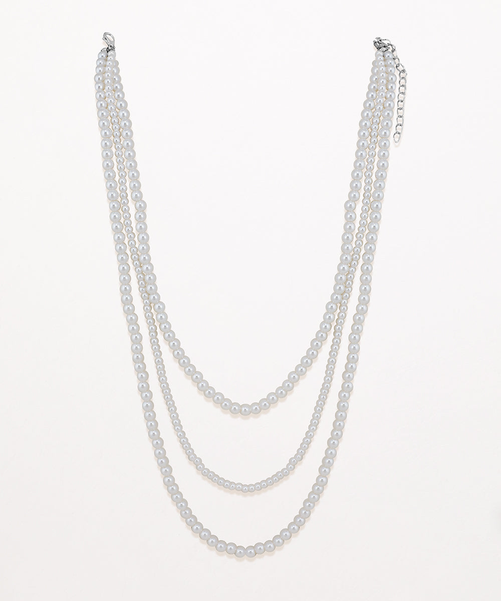 Rhodium finish multi-strand necklace with varying sizes of faux pearls layered together.