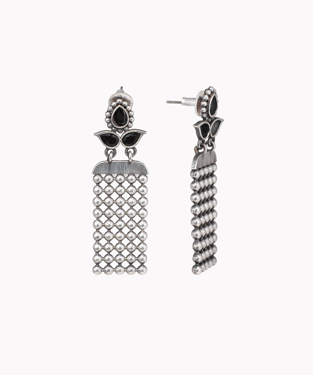 Pair of silver tassel earrings with black accents on a white background