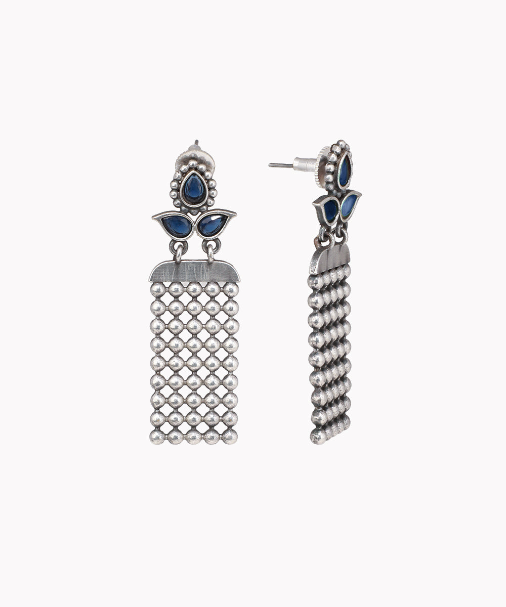 Pair of silver earrings with blue stones on a white background