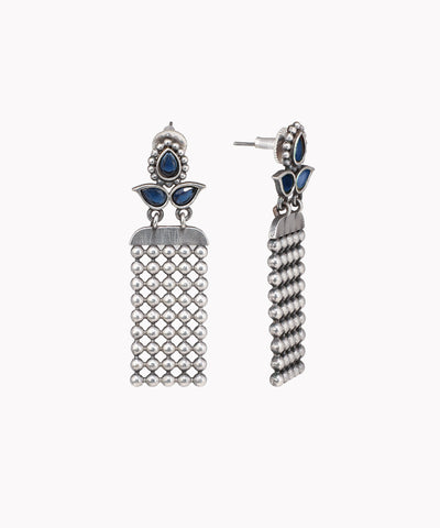 Pair of silver earrings with blue stones on a white background