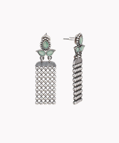 Pair of silver tassel earrings with green gemstones on a white background