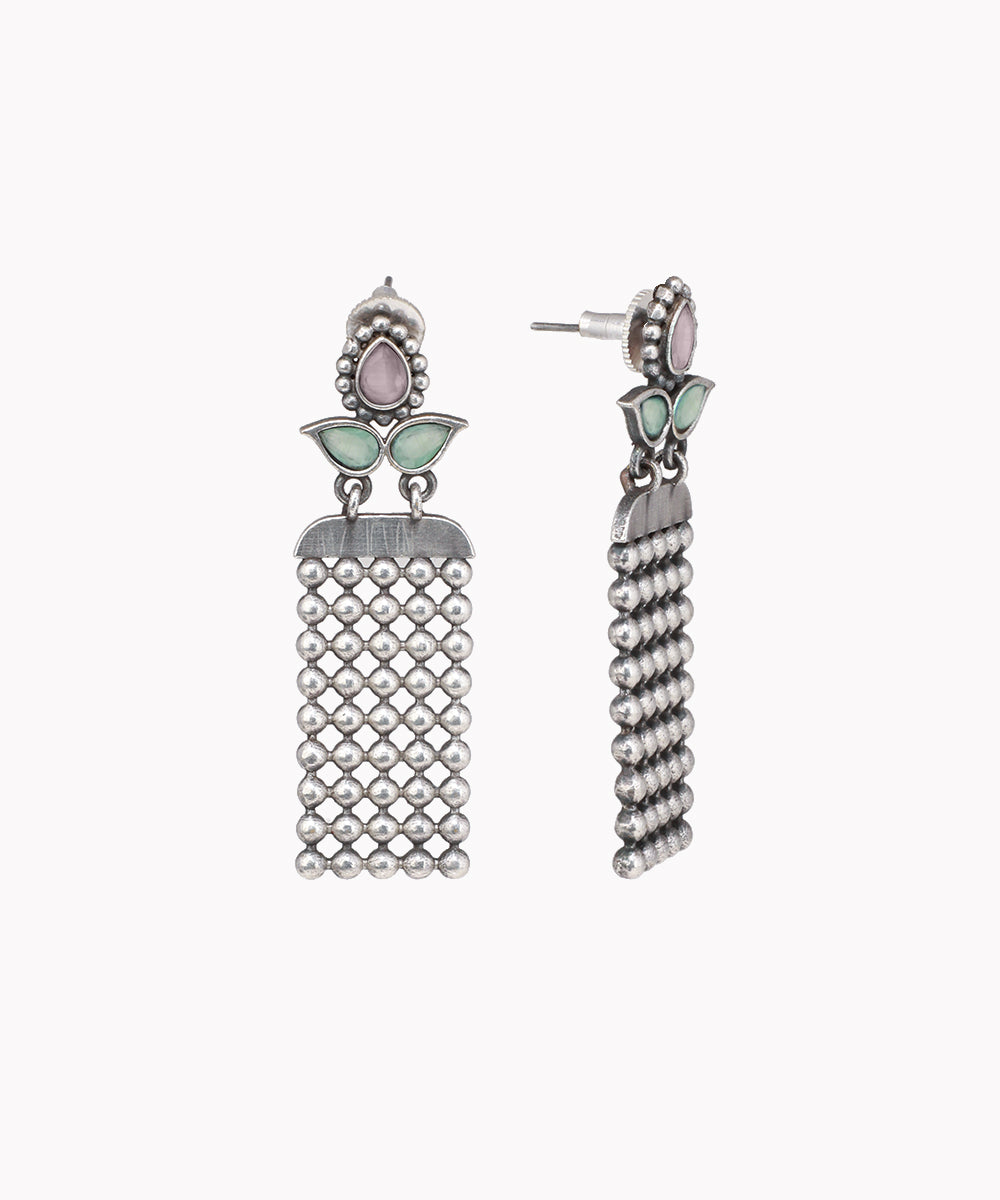 Pair of silver tassel earrings with green accents on a white background