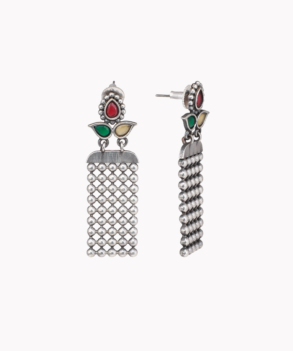 Oxidized silver-tone drop earrings with red, green, and cream colored stones and a rectangular beaded panel.