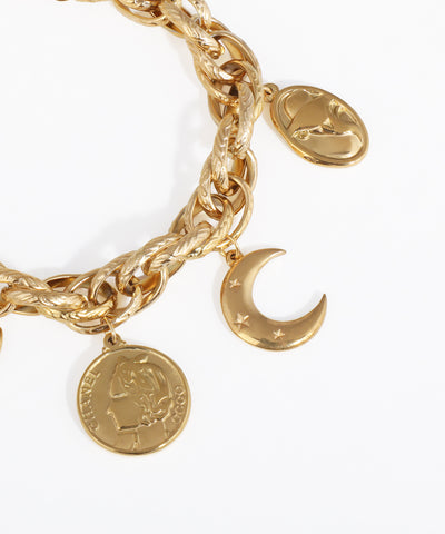 Gold chain bracelet with moon and coin charms on a white background