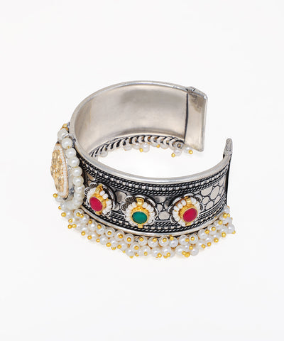 Silver cuff bracelet with colorful stones and pearl accents on a white background