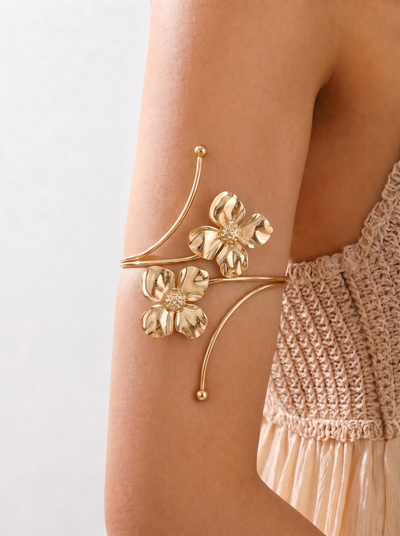 Gold floral arm cuff on a person's arm with a neutral background