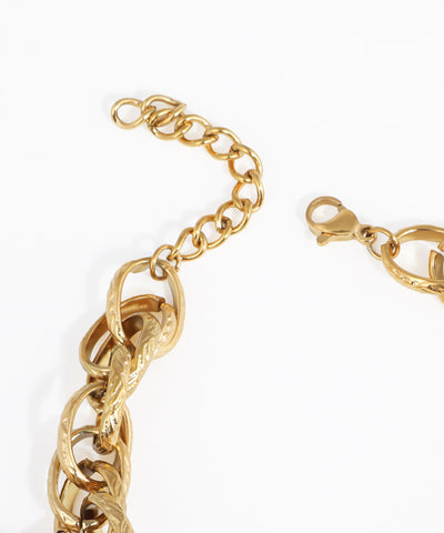Close-up of a gold chain bracelet on a white background