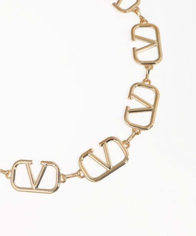 Gold necklace with 'V' shaped links on a white background