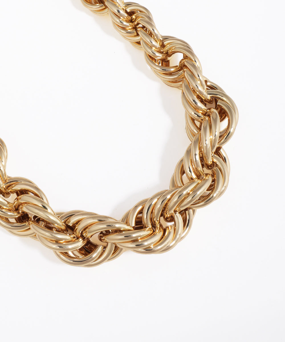 Gold rope chain necklace on a white background