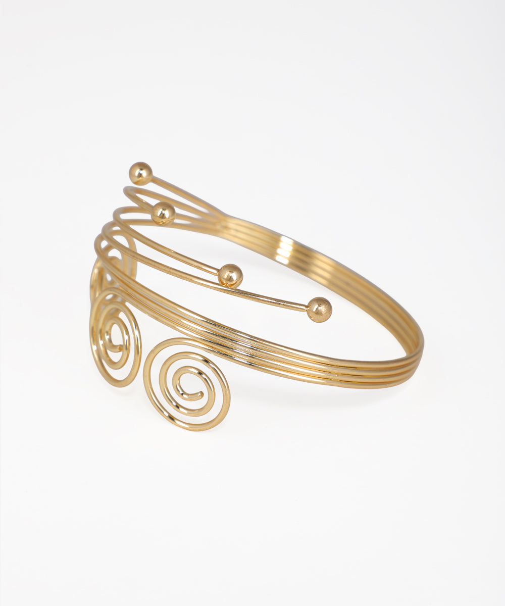 Gold bracelet with spiral design on a white background