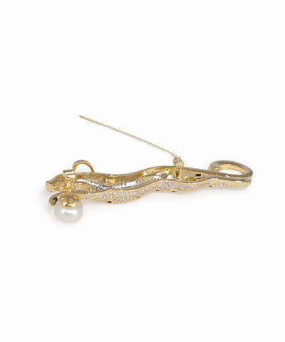 Gold brooch with a pearl on a white background