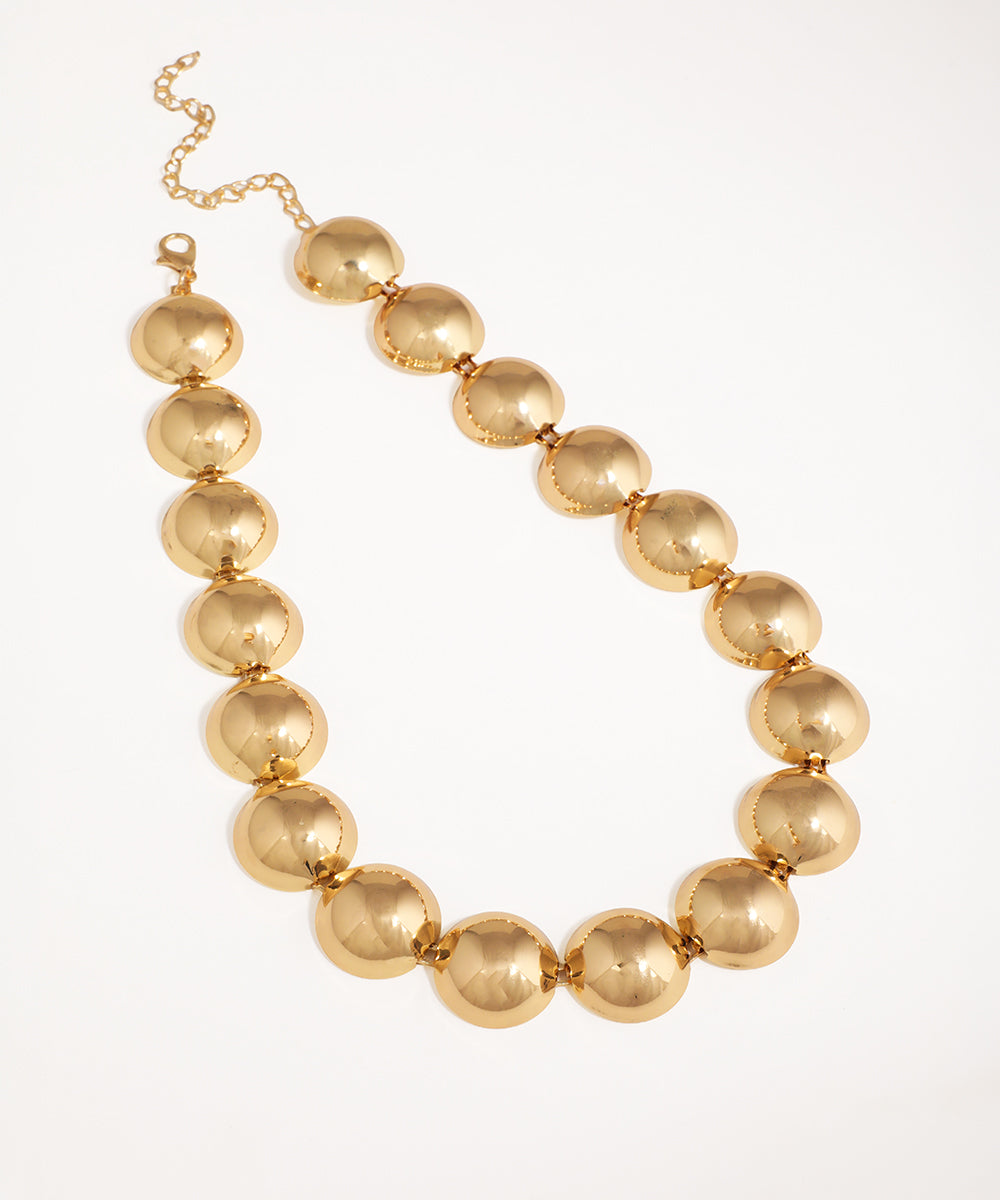 Gold-tone necklace with large polished domed segments, lobster clasp closure.