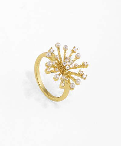 Gold-tone finger ring with a starburst cluster design, adorned with clear CZ stones and small faux pearls.