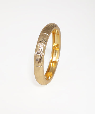 Gold ring with a textured design on a white background