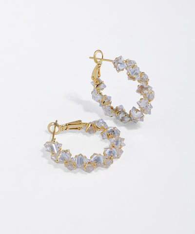 Gold-tone hoop earrings with irregular clear facet stones set around the band and a lever back closure.