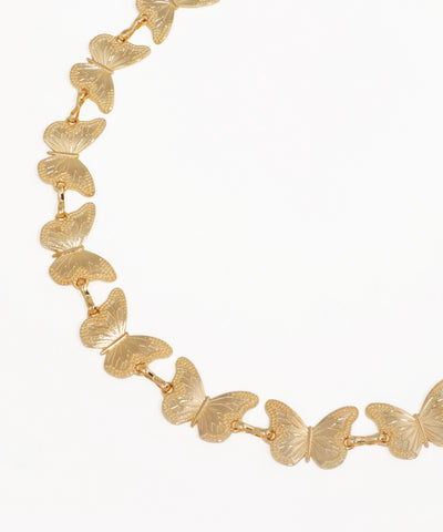 Gold butterfly necklace on a white background