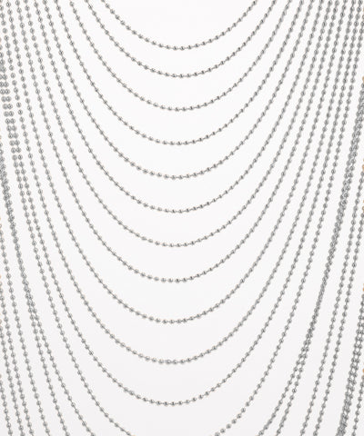 Multiple strands of silver beads on a white background