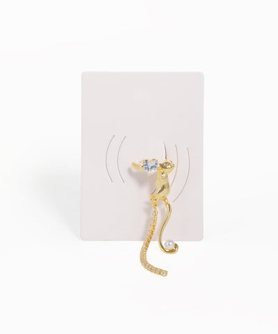 Gold cat-shaped earring on a white card with a white background