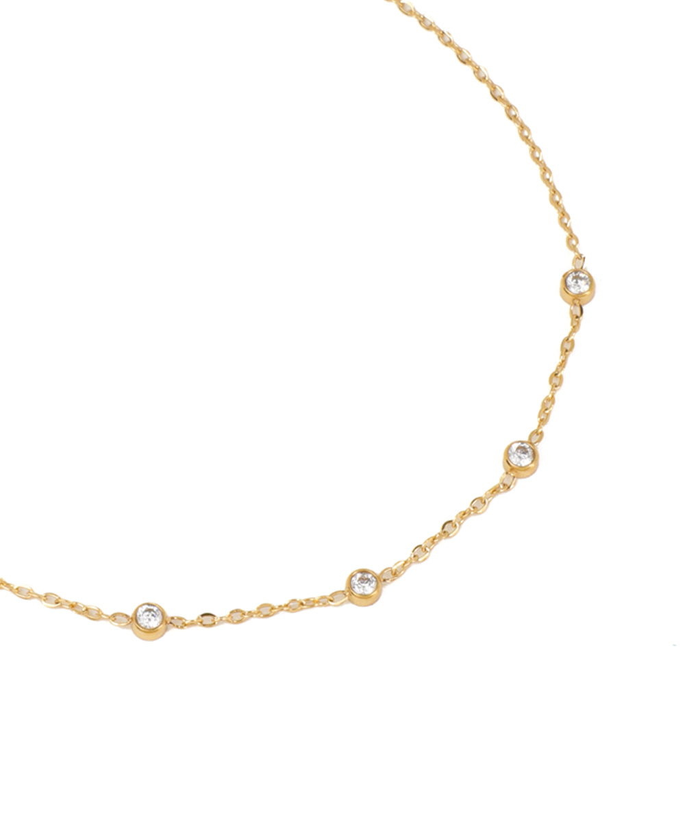 Gold necklace with small diamonds on a white background