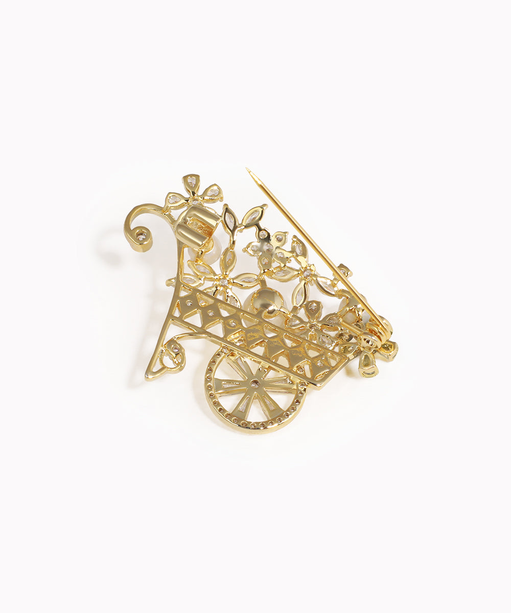 Gold brooch with intricate design on a white background