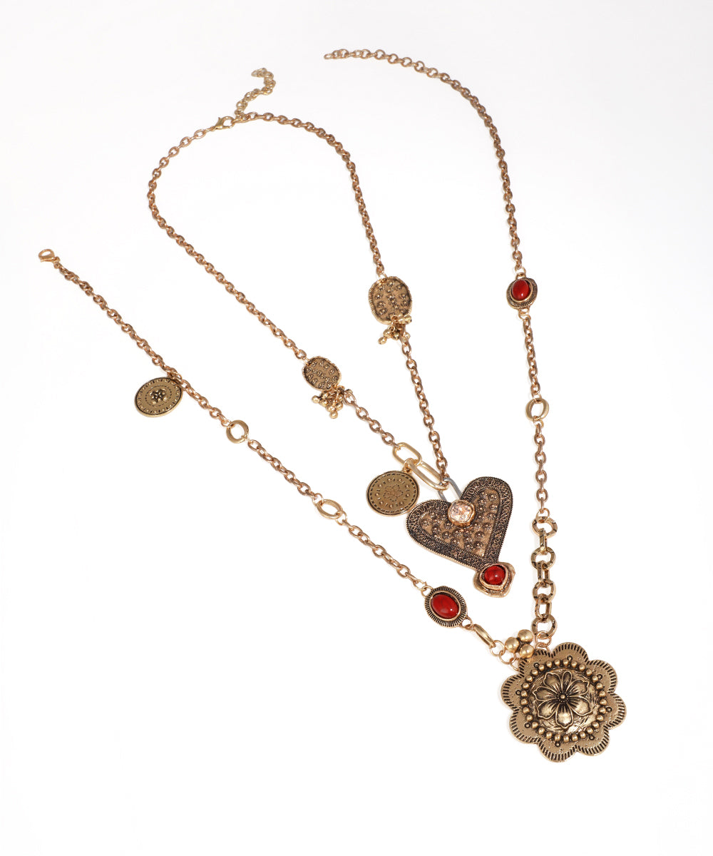 Antique gold-tone multi-layer necklace with heart, floral, and coin charms, featuring red and clear stones