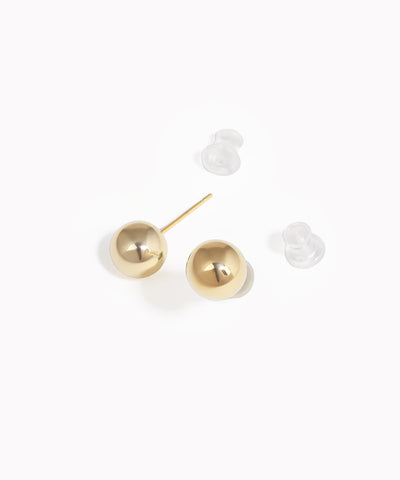 Gold ball earrings on a white background