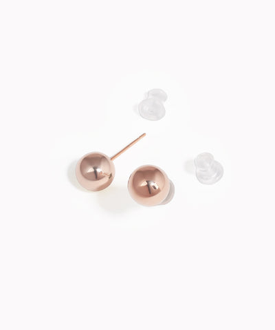 Rose gold ball earrings on a white background