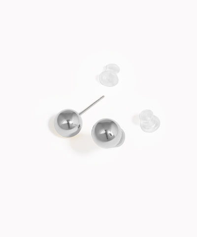 Pair of silver round earrings on a white background