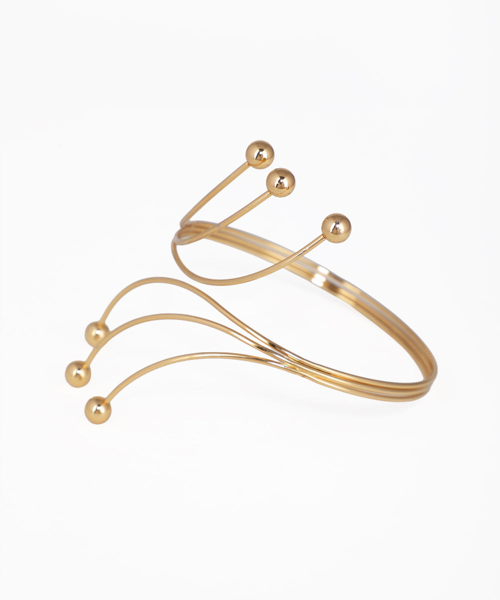 Gold bracelet with spherical accents on a white background