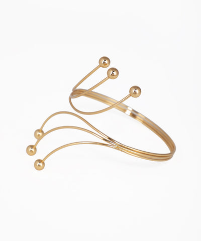 Gold bracelet with spherical accents on a white background
