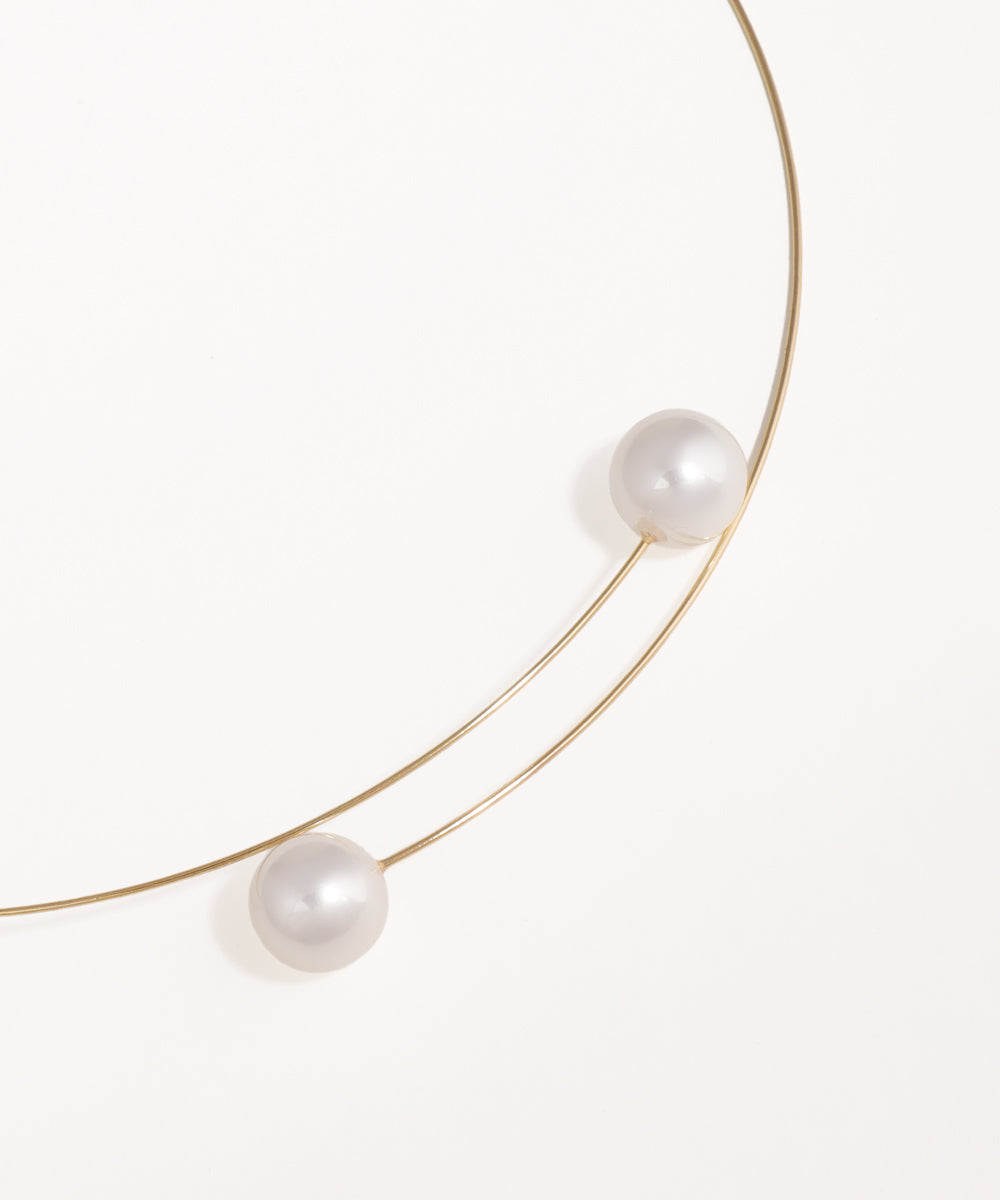 Gold necklace with three pearls on a white background
