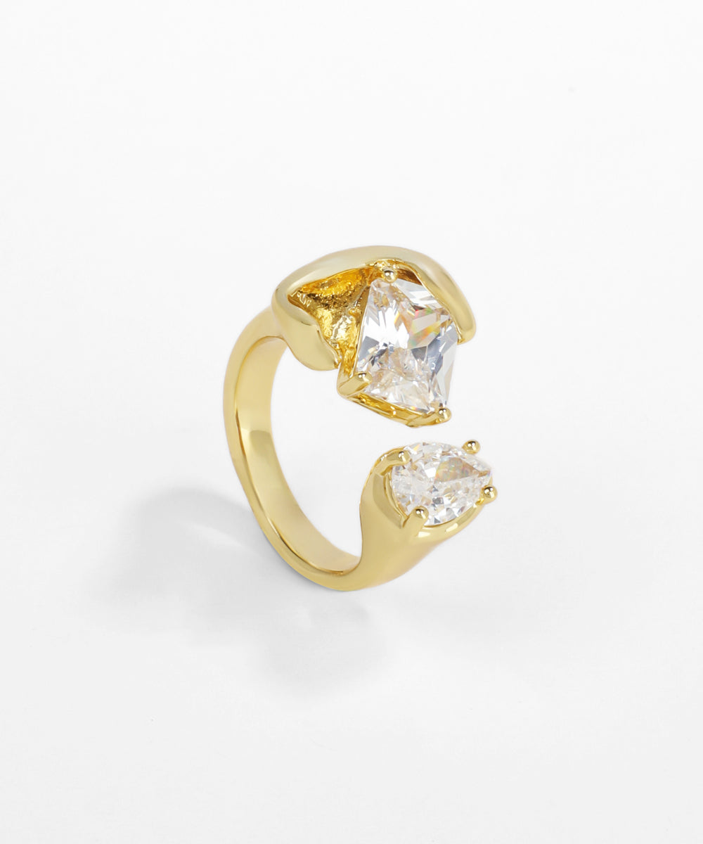 Gold ring with two clear gemstones on a white background