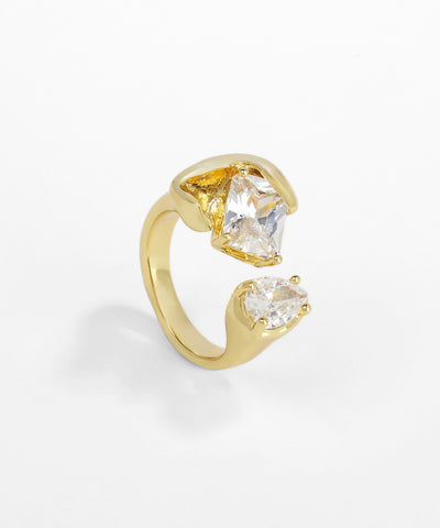 Gold ring with two clear gemstones on a white background