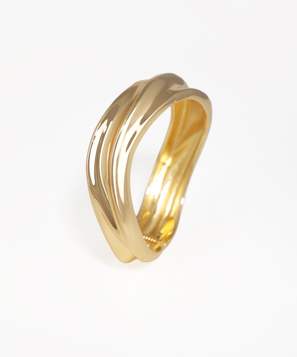 Gold-tone bangle kada with a polished, fluid, and twisted sculptural design
