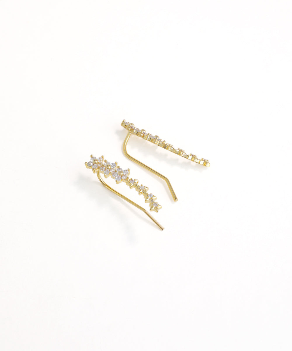 Gold hair clips with floral designs on a white background