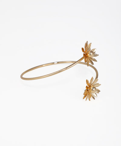 Gold bracelet with floral designs on a white background