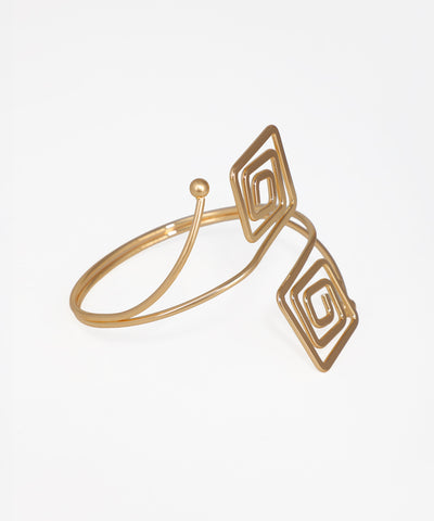 Gold ring with geometric design on a white background