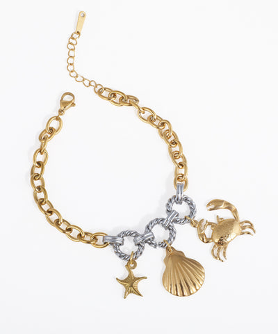 Gold-tone and rhodium finish chain bracelet with crab, seashell, and starfish charms.