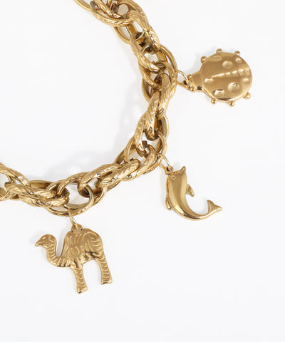 Gold chain bracelet with various charms on a white background