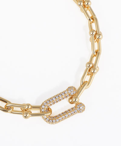 Gold chain bracelet with diamond accents on a white background