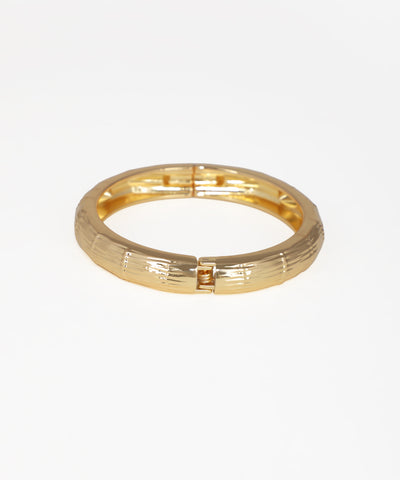 Gold ring with a textured design on a white background