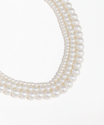 Three strands of pearls on a white background
