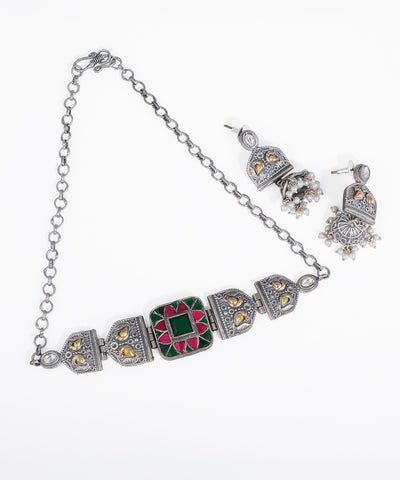 Antique finish necklace and jhumka earrings set with green and pink stones, gold-tone accents, and faux pearls.