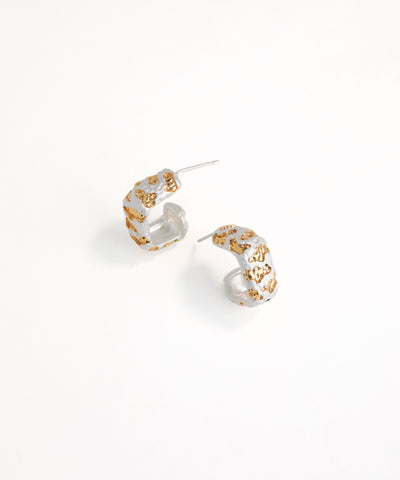 Pair of gold and white hoop earrings on a white background