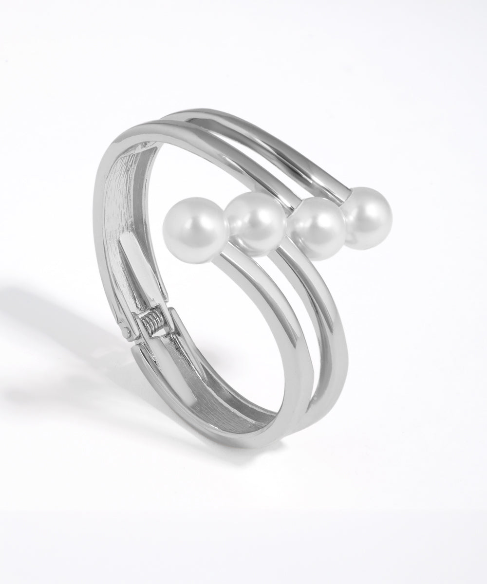 Silver ring with three pearls on a white background