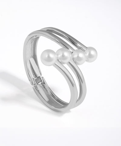 Silver ring with three pearls on a white background