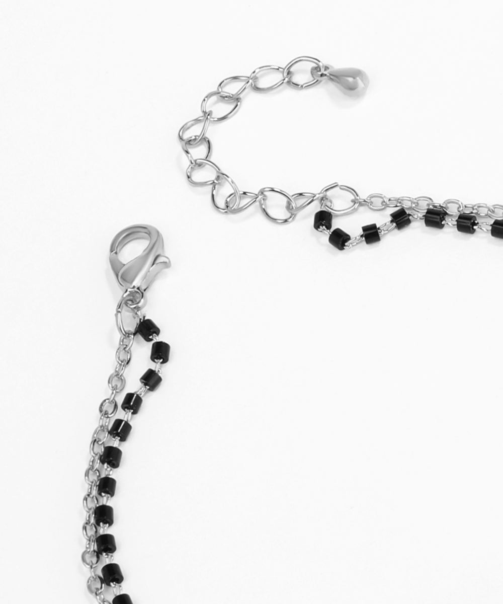 Close-up of a bracelet with black and clear beads on a white background